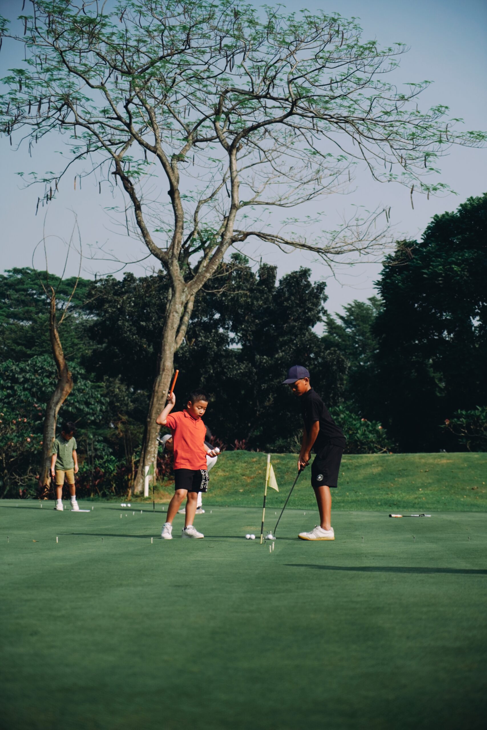 2 junior golfers practice putting on a fun set up