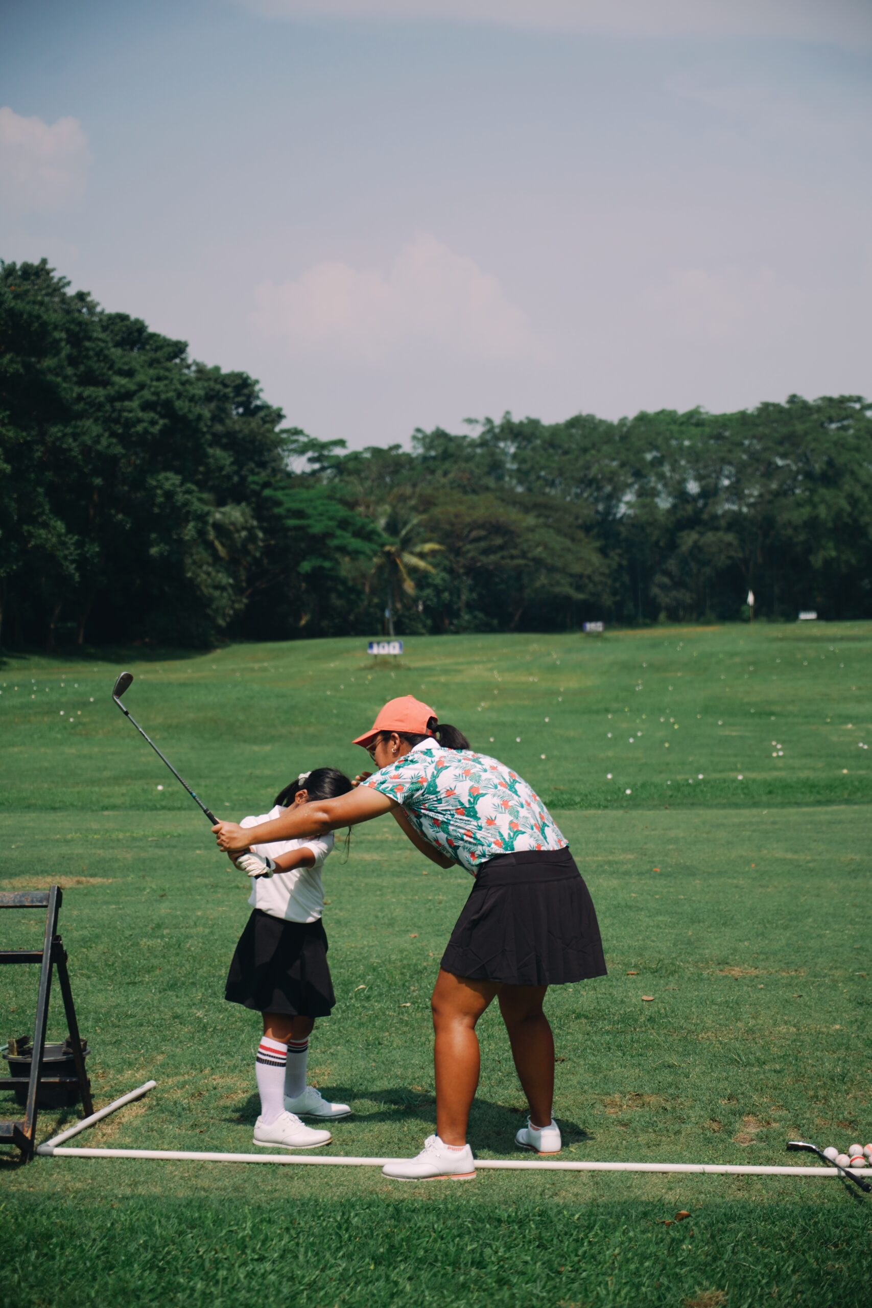 private lesson coach teaching a little girl how to swing